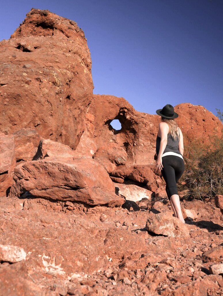 Monica on the red earth, looking up at the Hole in the Rock in Papago Park, Phoenix.