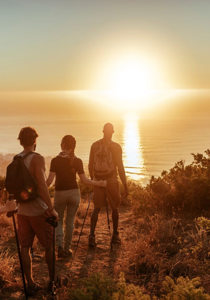 Things to Do on a Road Trip with Friends - three friends hiking near the ocean.
