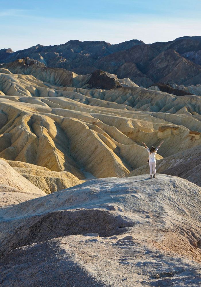 Monica in front of rugged mountains at Zabriskie Point in Death Valley National Park.
